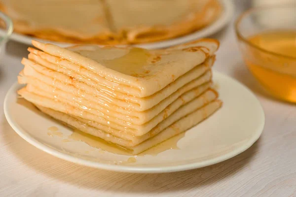 Maslenitsa is a national holiday at the end of February . pancakes with honey and milk on a light background. honey trickles down a stack of pancakes. close up. blini. space for text — Stock Photo, Image