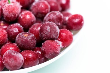 Beyaz arka planda donmuş taze kirazlar. Smoothie ve smoothie için bir malzeme. Böğürtlenli buz kristalleri. Dikey fotoğraf. Kapat..