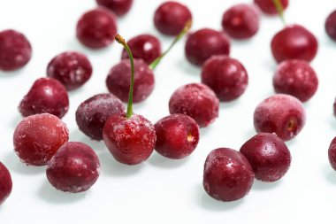 Beyaz arka planda bir grup donmuş kiraz. Yukarıdan manzara. Böğürtlenli buz kristalleri. Dikey fotoğraf. Kapat.