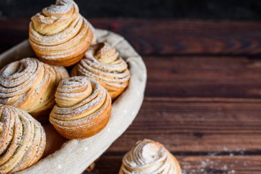 2020 'lerde modern pişirme eğilimi kabuklu kekler, poğaça kruvasan ve keklerin karışımı. Koyu ahşap bir masada, üzerine pudra şekeri serpiştirilmiş. Yukarıdan manzara. Kapat..
