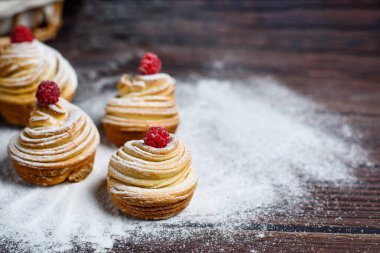 Modern moda fırın 2020-kabuklu kek, kruvasan ve kek karışımı. Koyu ahşap bir masada, üzerine pudra şekeri serpiştirilmiş. Kopyalanacak yer, yukarıdan görünüm.