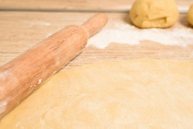 Yuvarlak hamurlu tereyağlı rulo ve rulo için merdaneyle. Yanında da kek kalıbı var. üstten görünüm, metin için yer.