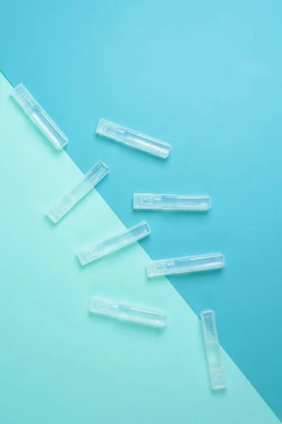 青い背景のコロナウイルスからの透明なフラスコの中の液体ワクチン 上からの眺め パンデミックに対する感染症の治療 — ストック写真