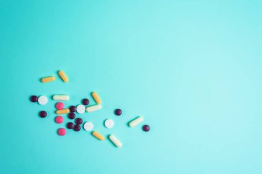 Haplar Coronavirüs 'ü tepeden görüyor. arkaplan resmi. Mavi arka planda kapsüller ve tabletler. Salgın sırasında enfeksiyon tedavisi. Konsept, salgın hastalıklar, koronavirüsler, düzen