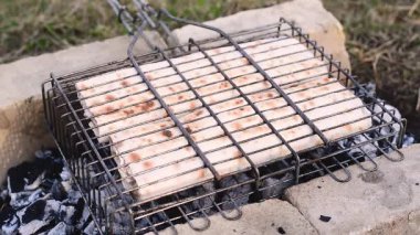 Pide ekmeğine sarılı et ateşteki ızgarada hazırlanır. Taze et rulosu. yüksek kaliteli video.