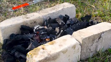 Izgaranın tuğlaları arasında barbekü için kömür yakmak. Çerçevede ateş ve duman alevleri. yüksek sıcaklıkta et pişirmek