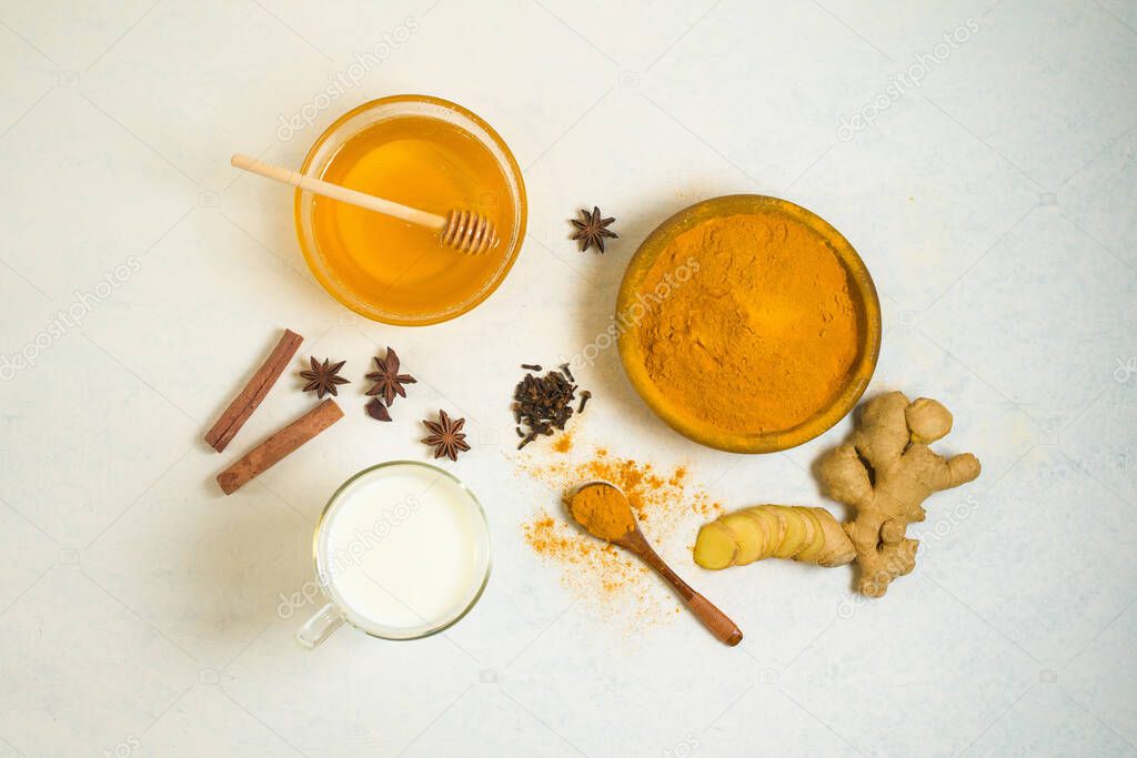 Indian traditional Golden milk with turmeric, ginger, spices, honey. healing effect of the drink. ingredients for a Golden drink on a light background. the view from the top