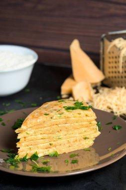 Yeşil peynirli tortilla peyniri koyu arkaplanda üçgen şeklinde kesilir. İçindekiler rendelenmiş peynir, yumurta, glütensiz nohut unu. Vejetaryen kahvaltısı. Yukarıdan görünüm.