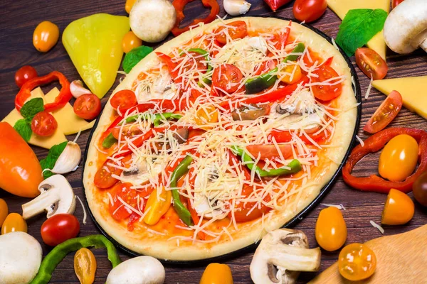 vegan pizza with vegetables, tomatoes, mushrooms, pepper. top view large view . ingredients for vegetarian pizza on a dark background.