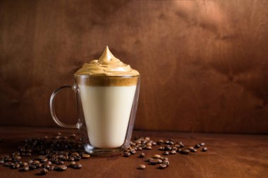 Koyu ahşap arka planda, berrak bardaklarda soğuk dalgon kahvesi. Şekerden köpük ve hazır kahve soğuk sütle karıştırılır. Kore ve Hindistan kremalı kahvesi.