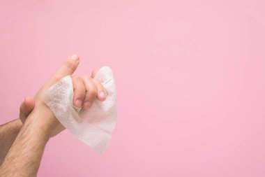 Koronavirüs salgını sırasında el dezenfeksiyonu için antimikrobik peçete. Pembe bir arka planda. Metin için boşluk.