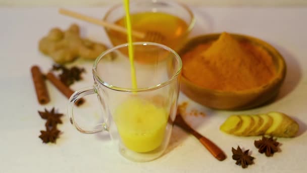 Goldenes Getränk Mit Kurkuma Und Milch Einem Klaren Glas Bestreut — Stockvideo