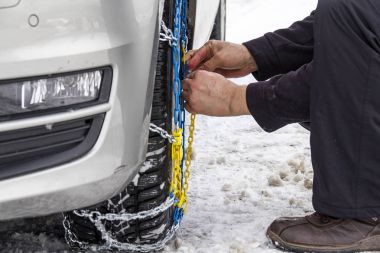 buzlu bir yolda bir araba üzerinde kar zincirleri monte 