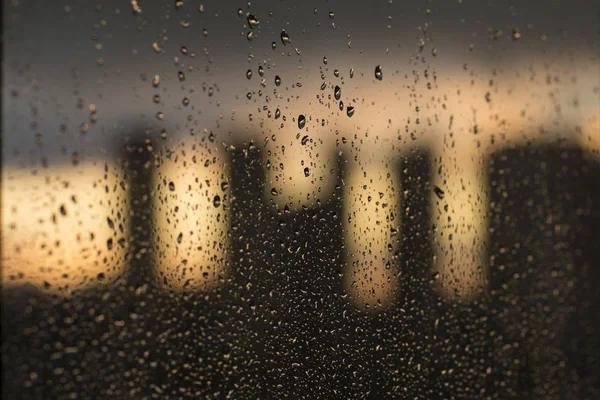 都市のぼやけた背景のウィンドウに雨粒します — ストック写真