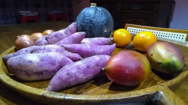 Kabak, portakal, mango, tatlı patates ve soğan ile ahşap tepsi 