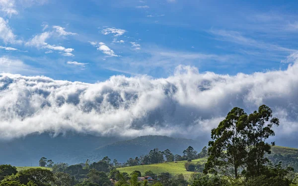 山を覆う雲 雲と霧に覆われた山のピーク — ストック写真