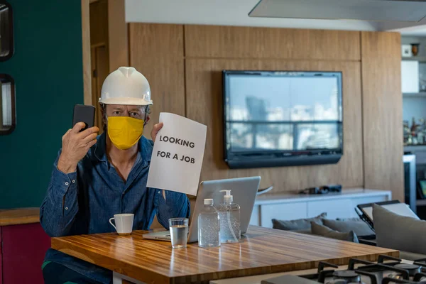 コロナウイルスの隔離の概念 仕事を探すために携帯電話を使って顔のマスクをした男 — ストック写真
