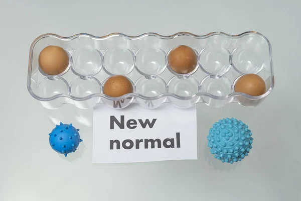 NEW NORMAL. New normal concept. Word with eggs in a box. Virus picture, Germs. COVID-19.