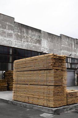 Yel değirmeninin kola, ahşap kurulları yığınları tahta (tahtalar). Açık havada kereste kurullarında testere için ambar. Ahşap Ahşap ahşap boşlukları İnşaat malzeme yığını. Sanayi.