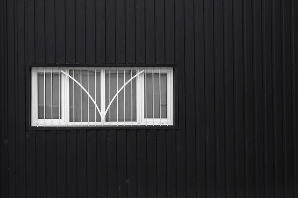 Superficie de textura de lámina de metal corrugado en blanco y negro en una pared de edificio con ventanas. Galvanizar fondo de acero . — Foto de Stock