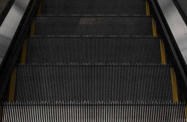 Moderno sistema electrónico de escaleras mecánicas en movimiento. Las escaleras mecánicas se están moviendo hacia arriba.El suelo es una línea recta. Negro con banda amarilla . —  Fotos de Stock