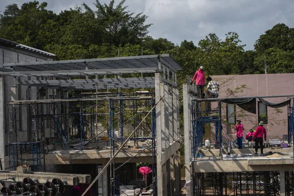 Phuket, thailand - februar 10, 2019. arbeiter arbeiten an dem neuen gebäude im aufbau. Betonbau eines neuen Mehrzweckgebäudes im Unterbau. — Stockfoto