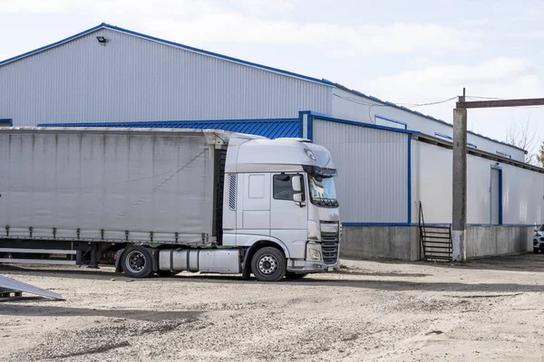 Moderne vrachtwagens van verschillende kleuren en modellen zijn betrokken bij het vervoer van verschillende soorten commerciële goederen zijn in een rij op truckstop in afwachting van de voortzetting van werkvluchten. — Stockfoto