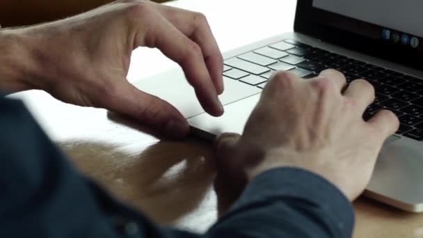 Händer affärsman med en överblick över mannen som arbetar på laptop medan du sitter vid träbordet på caféet. Diskutera organisatoriska ögonblick vid bord i café med en bärbar dator och telefoner. — Stockvideo