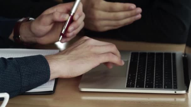 Händer affärsman med en överblick över mannen som arbetar på laptop medan du sitter vid träbordet på caféet. Diskutera organisatoriska ögonblick vid bord i café med en bärbar dator och telefoner. — Stockvideo