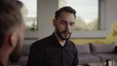 İki neşeli iş adamı bir şey tartışıyor ve kafede dizüstü bilgisayar ve telefonlarla otururken gülümsüyor. İki başarılı genç meslektaşımız, kafeteryadaki organizasyon anlarını teker teker tartışıyor..
