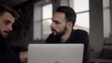 İki neşeli iş adamı bir şey tartışıyor ve kafede dizüstü bilgisayar ve telefonlarla otururken gülümsüyor. İki başarılı genç meslektaşımız, kafeteryadaki organizasyon anlarını teker teker tartışıyor..