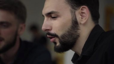 İki neşeli iş adamı bir şey tartışıyor ve kafede dizüstü bilgisayar ve telefonlarla otururken gülümsüyor. İki başarılı genç meslektaşımız, kafeteryadaki organizasyon anlarını teker teker tartışıyor..