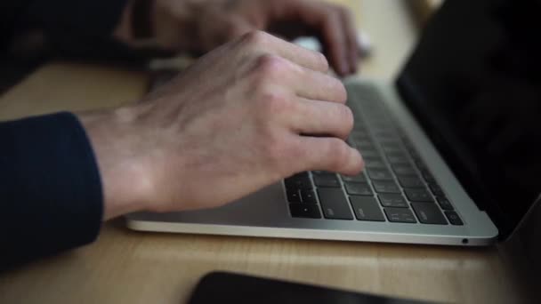 Mãos de homem de negócios com uma vista superior do homem que trabalha no portátil ao sentar-se na mesa de madeira no café. Discutindo momentos de organização por mesa no café com um laptop e telefones . — Vídeo de Stock