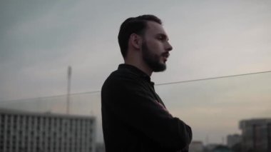 Genç iş arkadaşları gülerek bir şeyler tartışıyor ve akşamları yüksek bir yerde, gün batımında dışarıda dikiliyorlar. İş ortaklığı ya da iş arkadaşı diyaloğu.