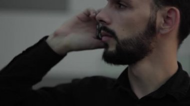 Genç işadamı dışarıda bir arkadaşıyla, iş ortağıyla ya da meslektaşıyla konuşarak akıllı telefon kullanıyor..