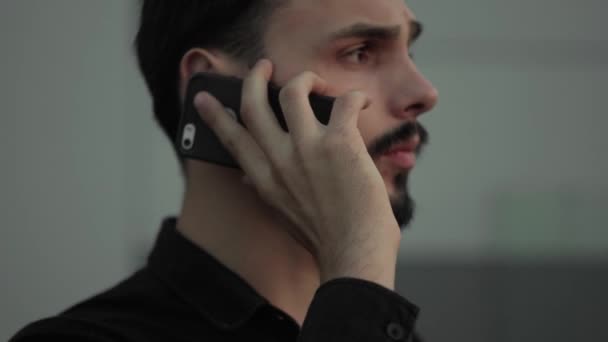 Joven hombre de negocios usando teléfono inteligente al aire libre hablando con un amigo, socio de negocios o colega . — Vídeos de Stock