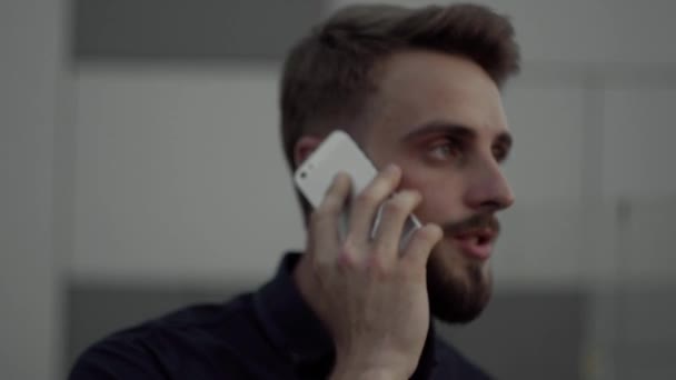 Giovane uomo d'affari che utilizza smartphone all'aperto parlando con un amico, un partner commerciale o un collega . — Video Stock