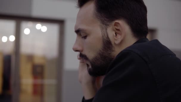 Joven hombre de negocios usando teléfono inteligente al aire libre hablando con un amigo, socio de negocios o colega . — Vídeos de Stock