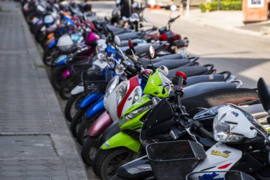 Krabi, Tayland - 10 Temmuz 2019. Krabi 'de motosikletlerle dolu her zamanki kalabalık park yeri. Turnuva alanında kaldırımda bir sürü motosiklet sıra sıra park ediyor..