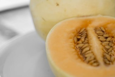 Taze portakallı kavun beyaz tabakta seçici bir odak noktası olarak duruyor. Faydalı ve vitamin zengini yiyecekler. Vejetaryen..