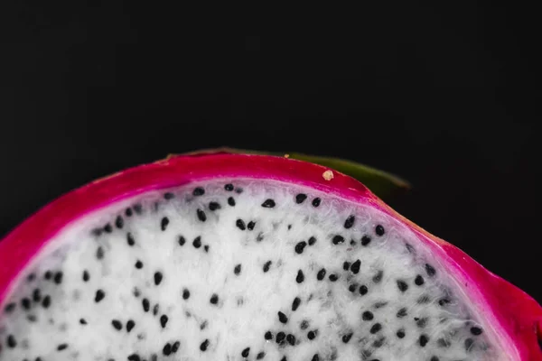 Dragon fruit. Vibrant Dragon Fruit on black background. Sliced white dragon fruit or pitaya on black plate on the table, close-up. Tropical and exotic fruits. Healthy and vitamin food concept.