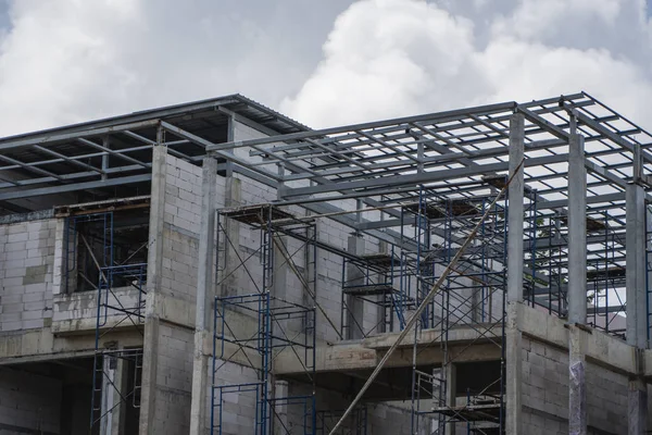 Baustelle im Gange. Baustelle gegen wolkenverhangenen Himmel. Metallkonstruktion des Rohbaus auf dem Bau des Mehrzweckgebäudes. — Stockfoto