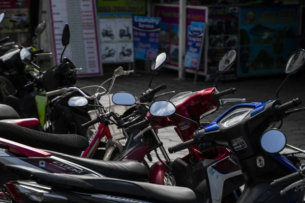 KRABI, TAILANDIA - 10 de julio de 2019. Lugar de estacionamiento habitual lleno de gente en Krabi con lleno de motos. Una gran cantidad de motocicletas aparcamiento en filas en la acera en lugar turístico . — Foto de Stock