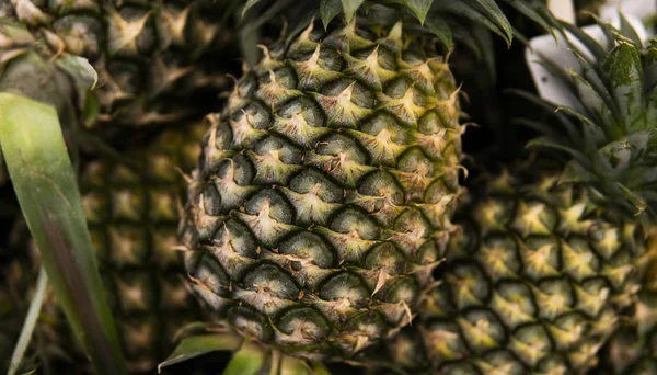 Um monte de frutas de abacaxi em um mercado no país asiático. Textura de fundo dos abacaxis. Frutos tropicais e exóticos. Conceito alimentar saudável e vitamínico . — Fotografia de Stock