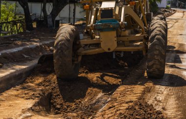 Grader yol inşaatında çalışıyor. Sınıf endüstriyel makine yeni yollar inşa ediyor. Otoyolda çalışan ağır iş makineleri. İnşaat malzemeleri. Yolun sıkıştırması.