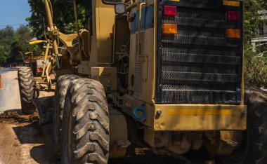 Grader yol inşaatında çalışıyor. Sınıf endüstriyel makine yeni yollar inşa ediyor. Otoyolda çalışan ağır iş makineleri. İnşaat malzemeleri. Yolun sıkıştırması.