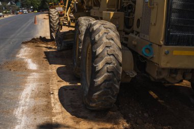 Yol inşaatında not verenlerin detayları üzerinde çalışıyor. Sınıf endüstriyel makine yeni yollar inşa ediyor. Otoyolda çalışan ağır iş makineleri. İnşaat malzemeleri. Yolun sıkıştırması.