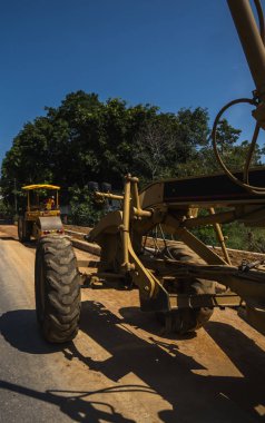 Yol inşaatında not verenlerin detayları üzerinde çalışıyor. Sınıf endüstriyel makine yeni yollar inşa ediyor. Otoyolda çalışan ağır iş makineleri. İnşaat malzemeleri. Yolun sıkıştırması.