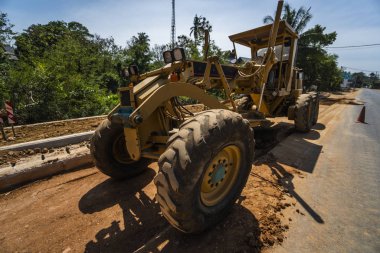 Grader yol inşaatında çalışıyor. Sınıf endüstriyel makine yeni yollar inşa ediyor. Otoyolda çalışan ağır iş makineleri. İnşaat malzemeleri. Yolun sıkıştırması.