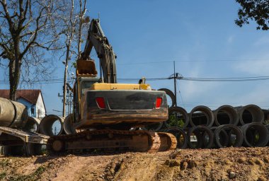 Büyük boruları bir araca aktarmak için kazıcı kullanmak.
